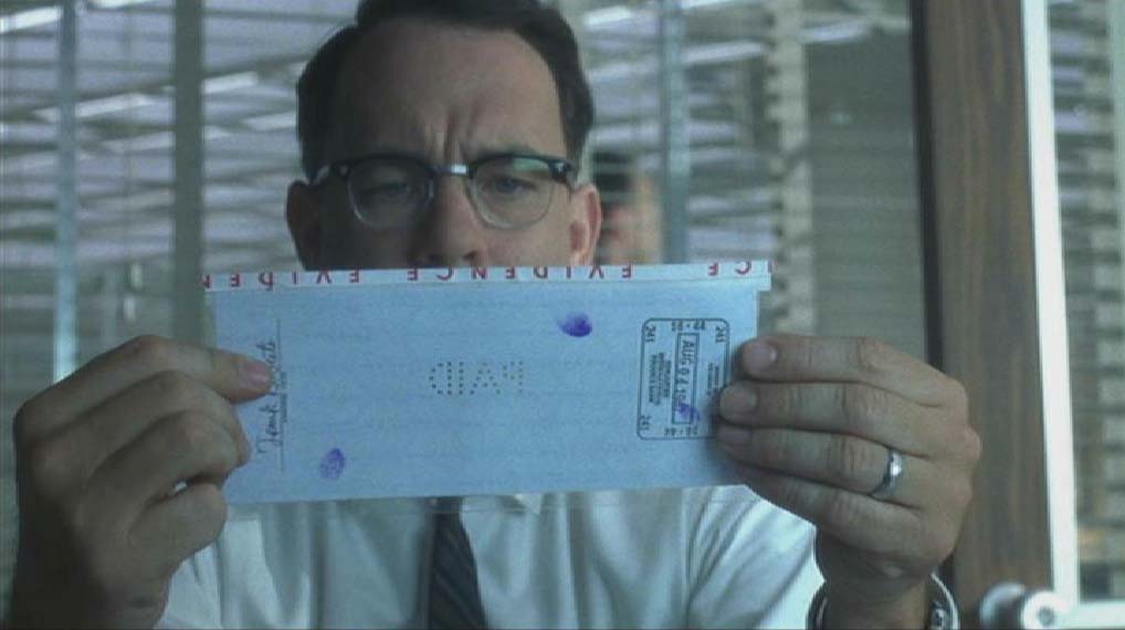 F.B.I. agent Carl Hanratty studies perforated check